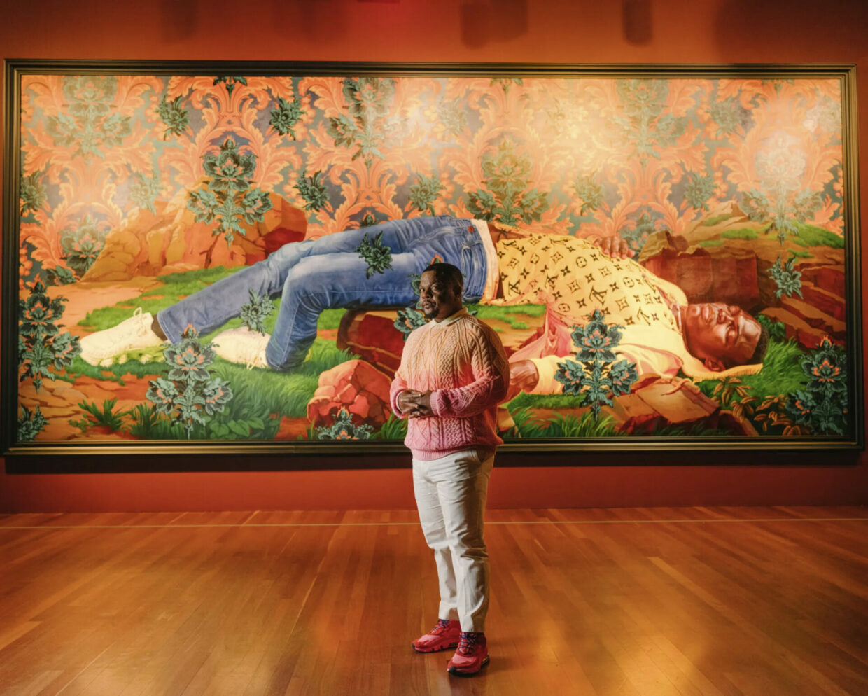 Kehinde Wiley at “An Archaeology of Silence” at the de Young Museum in San Francisco with his monumental 2022 painting, “Femme piquée par un serpent (Mamadou Gueye).” Works were made in response to the killings of Black men and women — “bodies chopped down,” the artist said. This one nods to an 1847 sculpture “Woman Bitten by a Serpent” by Auguste Clésinger.